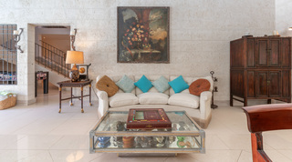 Living-room detail with floral oil painting and coral-stone wall at Jamoon, Barbados