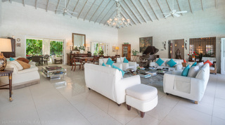 Open-plan living room under a vaulted ceiling and chandelier at Jamoon villa rental, Barbados