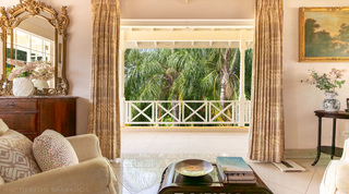 First-floor balcony with X-frame balustrade and treetop view at Jamoon villa, St. James, Barbados