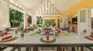 Casual terrace dining table set beneath the vaulted ceiling at Jamoon, Sandy Lane villas, Barbados