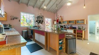 Kitchen with central island and granite worktops at Jamoon, Barbados