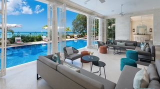 Kiko Villa indoor seating area looking out to sea across the swimming pool through open shutters