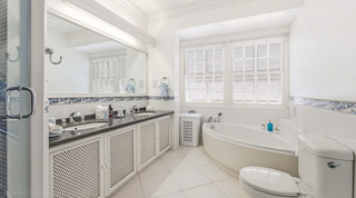 Mahogany Bay – Chanel No.5's en-suite bathroom with an oval bath below shuttered windows, Barbados