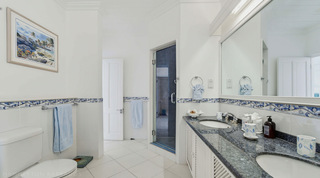 En-suite bathroom with twin granite basins and a walk-in shower at Mahogany Bay – Chanel No.5, Barbados