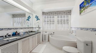 Corner soaking tub and twin-basin granite vanity in a Fathom's End en-suite bathroom, Barbados