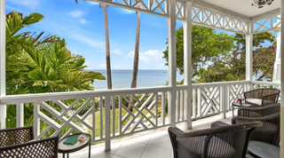 Morning coffee on a palm-framed balcony overlooking the Caribbean Sea at Fathom's End, Barbados