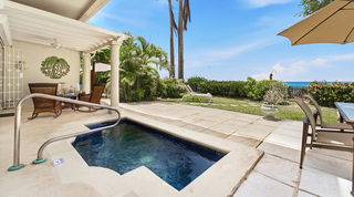 Wicker rocking chairs on the shaded plunge-pool verandah at Fathom's End, a holiday villa in Barbados