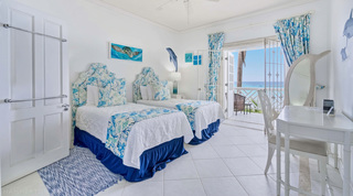 Twin bedroom with a sea-turtle theme and balcony doors to the ocean at Fathom's End, Barbados