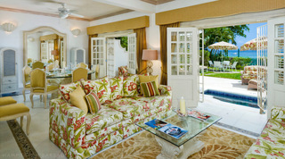 Floral sofas and glass dining table opening to the private plunge pool at Mahogany Pod, Barbados