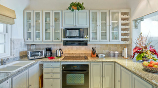 Fully equipped kitchen with granite worktops and glass-fronted cabinets, Mahogany Pod villa, Barbados