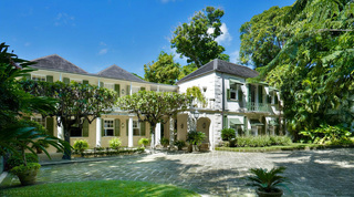 Coral stone facade with green shutters and frangipani-shaded courtyard at Mango Bay, beachfront villa in Barbados