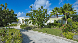 Curving driveway to the white rotunda entrance and shuttered facade of Monkey Hill, a private villa in Barbados