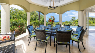 Round table under a ring chandelier in the arched gazebo with the sea beyond, Monkey Hill in St. James, Barbados