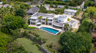 Bird's-eye view of Monkey Hill's infinity pool and lawns, with the cottage and garages behind, a luxury villa in Barbados