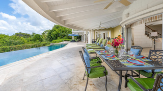 Alfresco dining and loungers on the covered terrace by the infinity pool at Monkey Hill, a holiday villa in Barbados