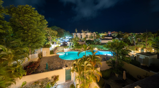 Free-form communal pool and rock waterfall floodlit after dark, Mullins Bay 13 Coco villa in Barbados
