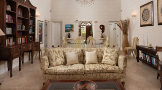 Coral stone living room of Mullins Bay Villa – Twin Palms in Barbados, with a damask sofa and crystal chandelier