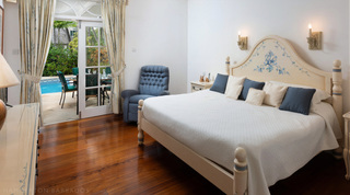 Blue floral vines painted on a cream headboard, doors open to the pool terrace, Mullins Bay Villa – Twin Palms in Barbados