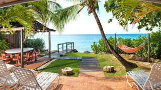 Beach house terrace with shaded dining, hammock and sun loungers on Gibbs Beach at Mullins Mill, Barbados