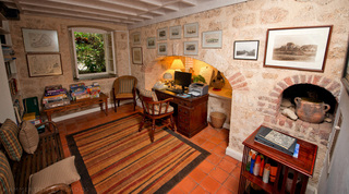 Stone-walled study with writing desk, fireplace alcove and framed maps at Mullins Mill, Barbados