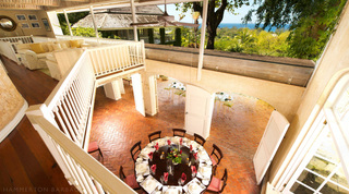 View from the gallery to the verandah lounge and round dining table with the ocean beyond at Mullins Mill, Barbados