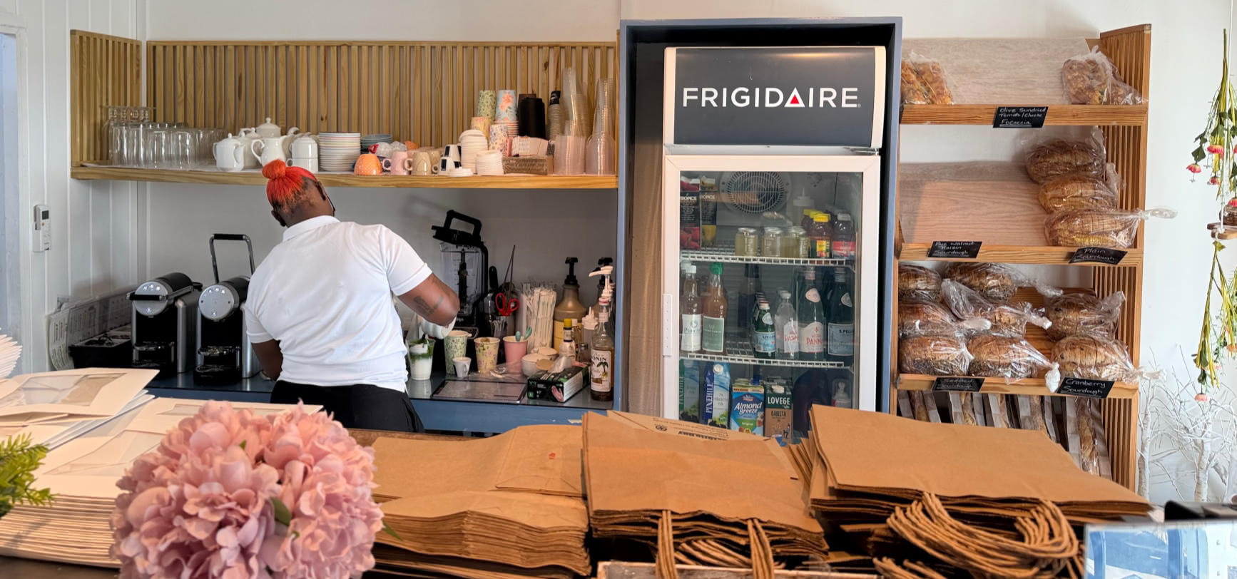 The Cliff Bakery's Holetown interior with coffee being prepared behind the counter 