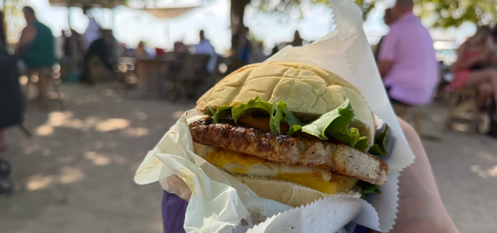 A loaded fish cutter at Caboose — grilled catch-of-the-day fillet with cheese, egg and lettuce in a Bajan salt-bread bun