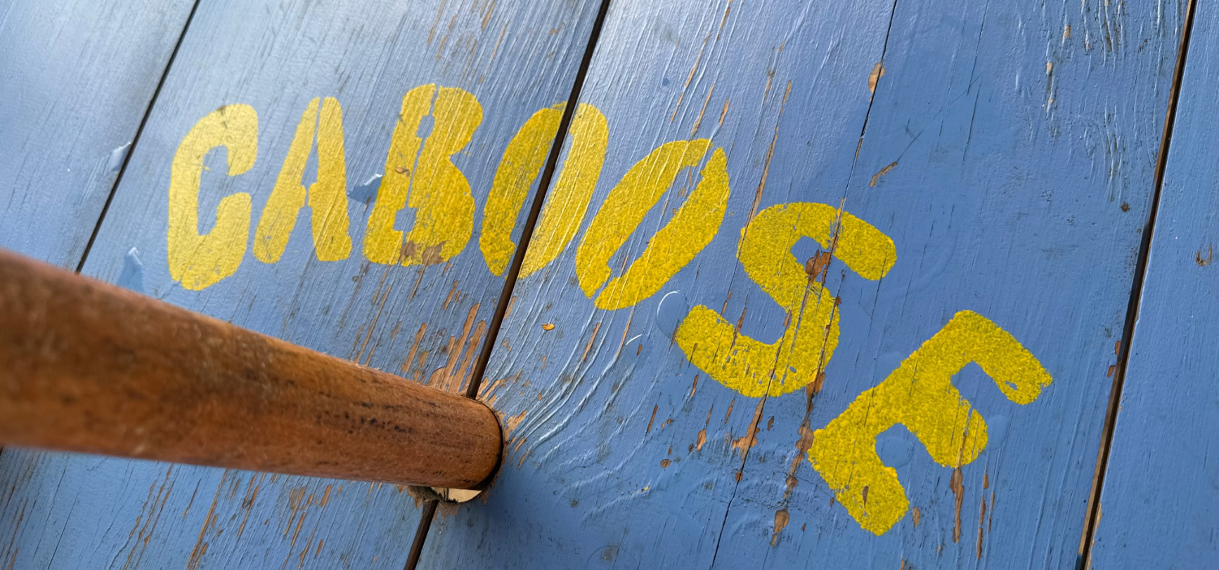 Yellow painted Caboose lettering on the blue painted ourdoor table