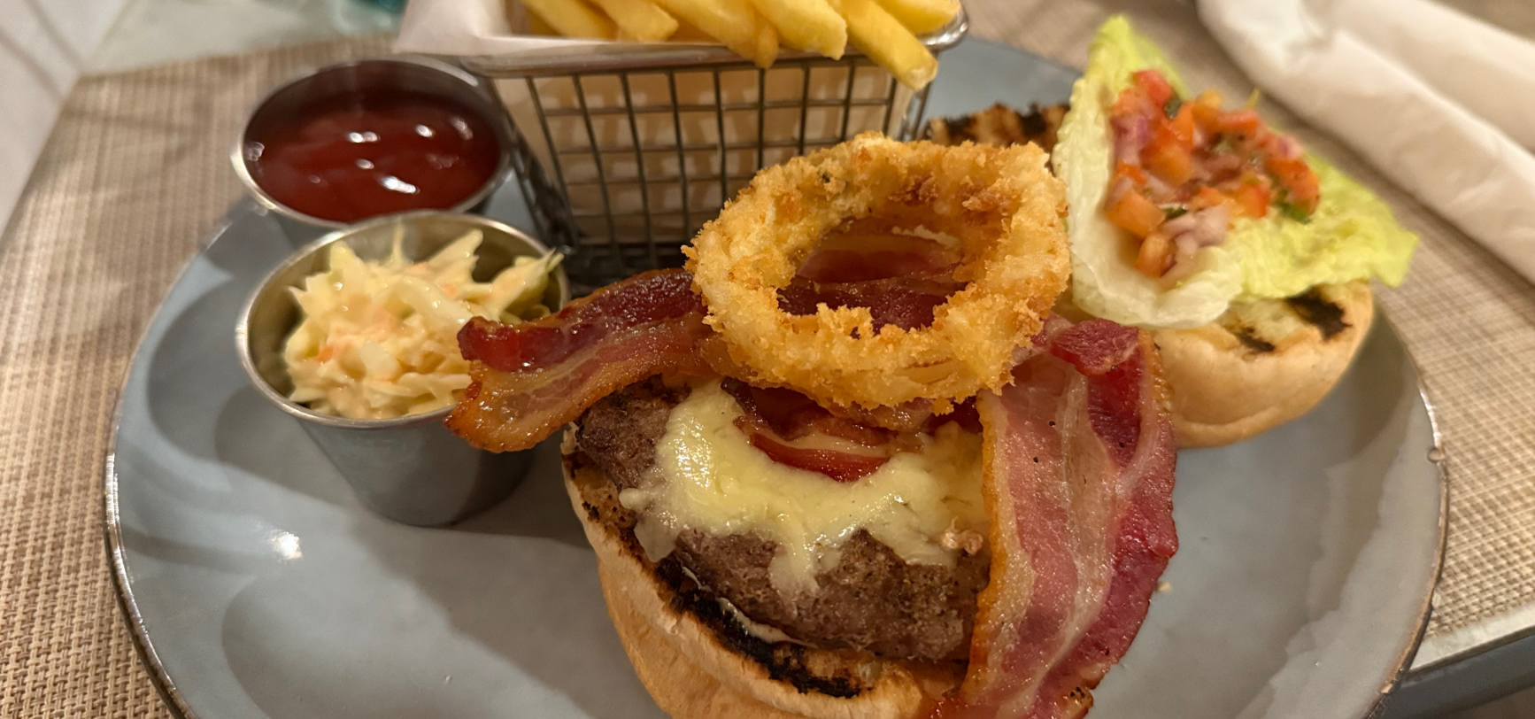 The Sand Street Burger with bacon, a panko onion ring and a basket of shoestring fries and slaw