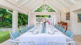 Alfresco dining pavilion with a long table set beneath a candle chandelier at Queens Fort Pavilion, luxury villa in Barbados