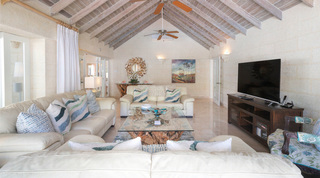 Petal-framed round mirror above a root-wood console in the TV lounge at Queens Fort Pavilion in Barbados
