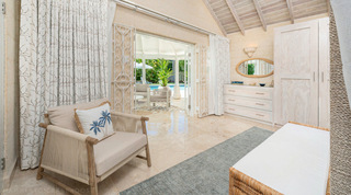 Bedroom with white scrolled gates and doors opening onto the poolside gazebo at Queens Fort Pavilion villa, Barbados