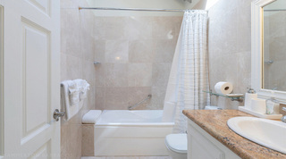 Queens Fort Pavilion bathroom with a tub and white shower curtain beside a single-basin vanity, Barbados