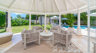 Open-sided octagonal gazebo with rope-back armchairs and a coral-print rug at Queens Fort Pavilion villa, Barbados