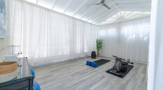 Private gym and yoga space with a rowing machine, dumbbells and exercise balls at Queens Fort Pavilion in Barbados