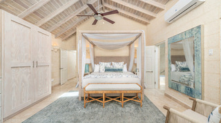 Four-poster bedroom with a white canopy and rope-wrapped posts at Queens Fort Pavilion, holiday villa in Barbados