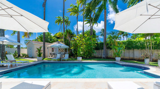 Pool deck under white parasols looking across to the pool bar and royal palms, Queens Fort Pavilion villa rental, Barbados