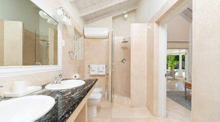 En-suite with twin basins and a glass shower, opening through to the gazebo and pool at Queens Fort Pavilion, Barbados