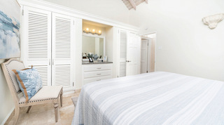 Bedroom with louvred white wardrobes and a lit dressing niche at Queens Fort Pavilion villa in St. James, Barbados