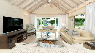 Queens Fort Pavilion's TV lounge with cream leather sofas and the pool beyond open glass doors, Barbados