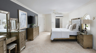 Bedroom at Royal Villa 17 in Barbados, with a charcoal feature wall and a mirrored dressing table
