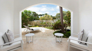 Covered terrace armchairs framing the tropical garden at Royal Villa 17, a villa rental in Barbados
