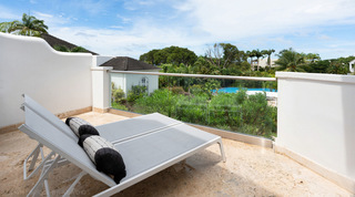 Double sun lounger on a glass-edged terrace at Royal Villa 17 in Barbados, above the resort gardens