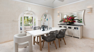 Dining table below a framed mirror at Royal Villa 17 in Barbados, set for relaxed island meals