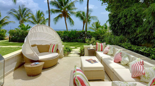 Beach-front lanai with a canopied daybed and the sea beyond at Smugglers Cove 1 in Barbados