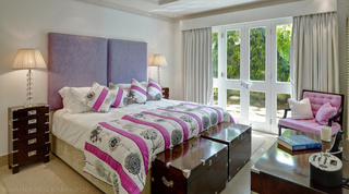 Bedroom with a lilac headboard and French doors to a leafy garden, Smugglers Cove 1, Barbados