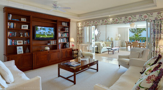 Mahogany media unit and twin sofas in the living room of Smugglers Cove 1, apartments in Barbados