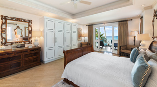 Sea-view bedroom with a dark wood sleigh bed and doors open to the terrace, Smugglers Cove 3 holiday apartment, Barbados