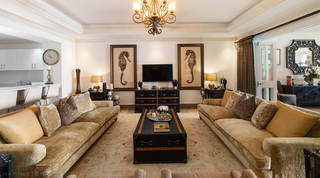 Twin plush gold sofas across a trunk coffee table, breakfast bar beyond, at Smugglers Cove 3 in St. James, Barbados