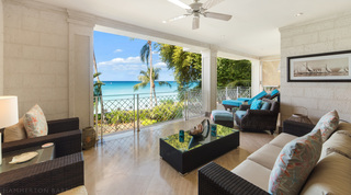 Terrace lounge open to palms and the Caribbean Sea, turquoise sun loungers beyond, at Smugglers Cove 3, Barbados